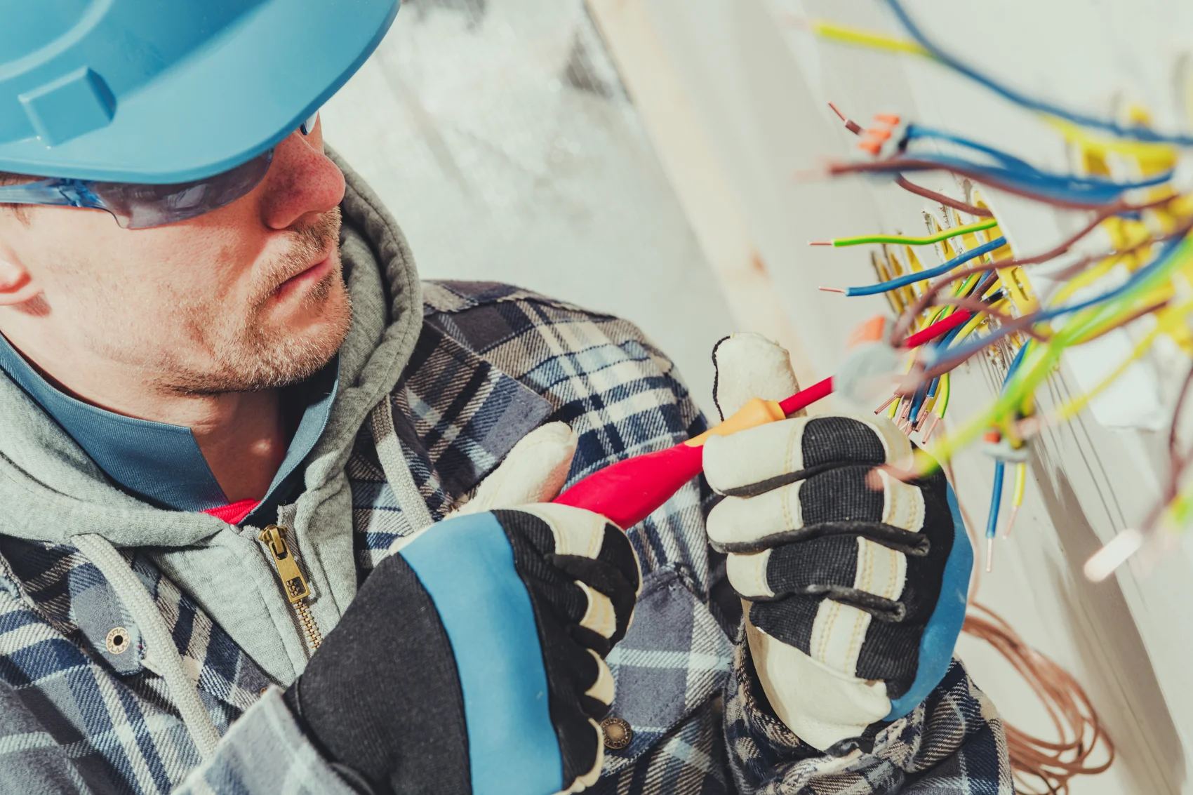 Technician installing power outlets during a home remodel before the walls are closed